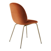 Orange velvet chair with a smooth, curved back and slender metal legs. Ideal for modern interior decor.