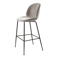 Gray upholstered bar stool with smooth curves and sleek black metal legs, perfect for modern decor.