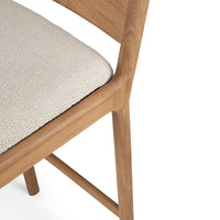 Beige textured cushion with warm wood tones, showcasing minimalist design and modern aesthetics.