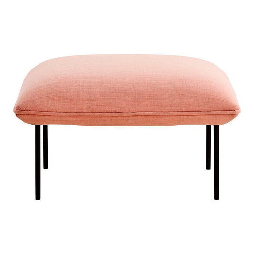 Pink upholstered ottoman with a smooth texture and sleek black legs. Ideal for modern home decor.