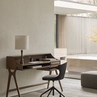 "Elegant wooden desk with clean lines, paired with a textured black chair in a modern, neutral-toned room."