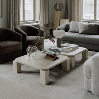 Luxurious living room featuring earthy tones, textured fabrics, and minimalist gray and beige patterns.