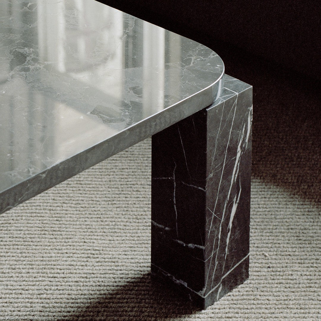 Gray marble coffee table with a polished surface and a bold black base featuring striking white veining patterns.