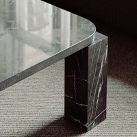 Gray marble coffee table with a polished surface and a bold black base featuring striking white veining patterns.