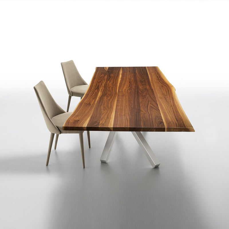 Rustic brown wood tabletop with striking grain patterns, paired with minimalist beige chairs on a sleek gray surface.
