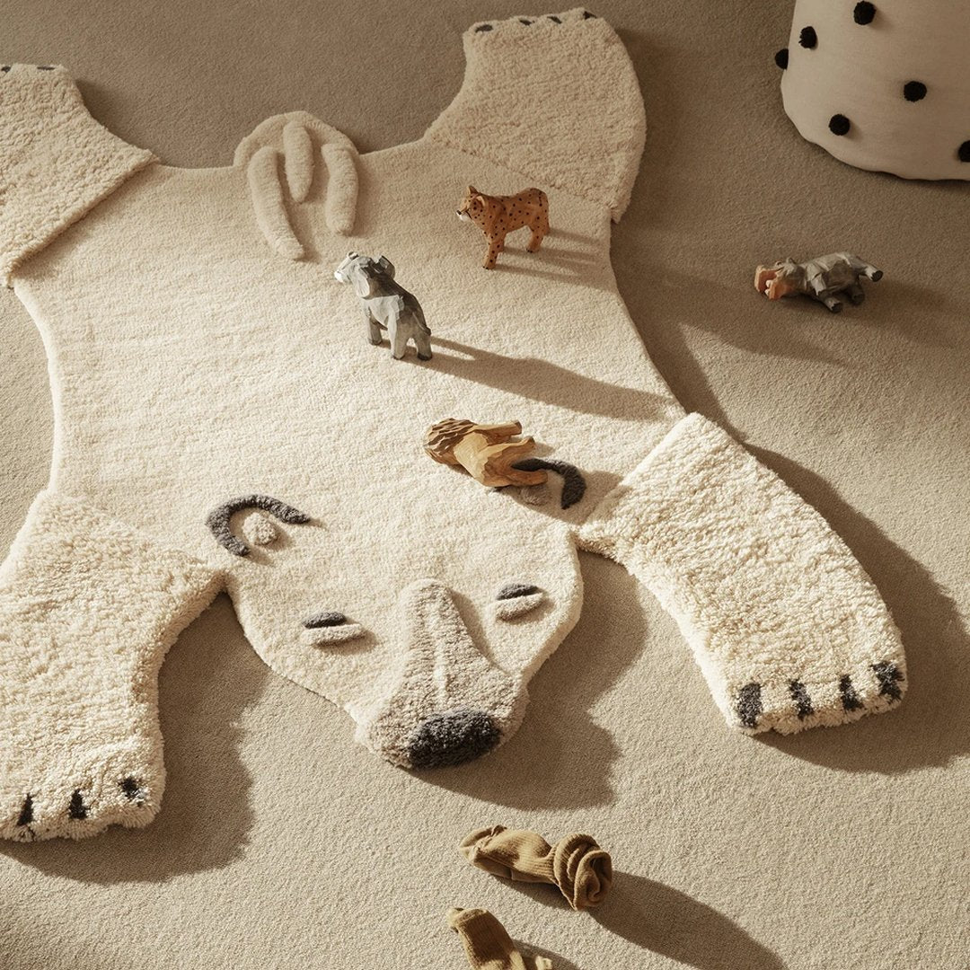 Cozy polar bear rug in soft cream with black accents, featuring a fluffy texture and playful animal patterns.