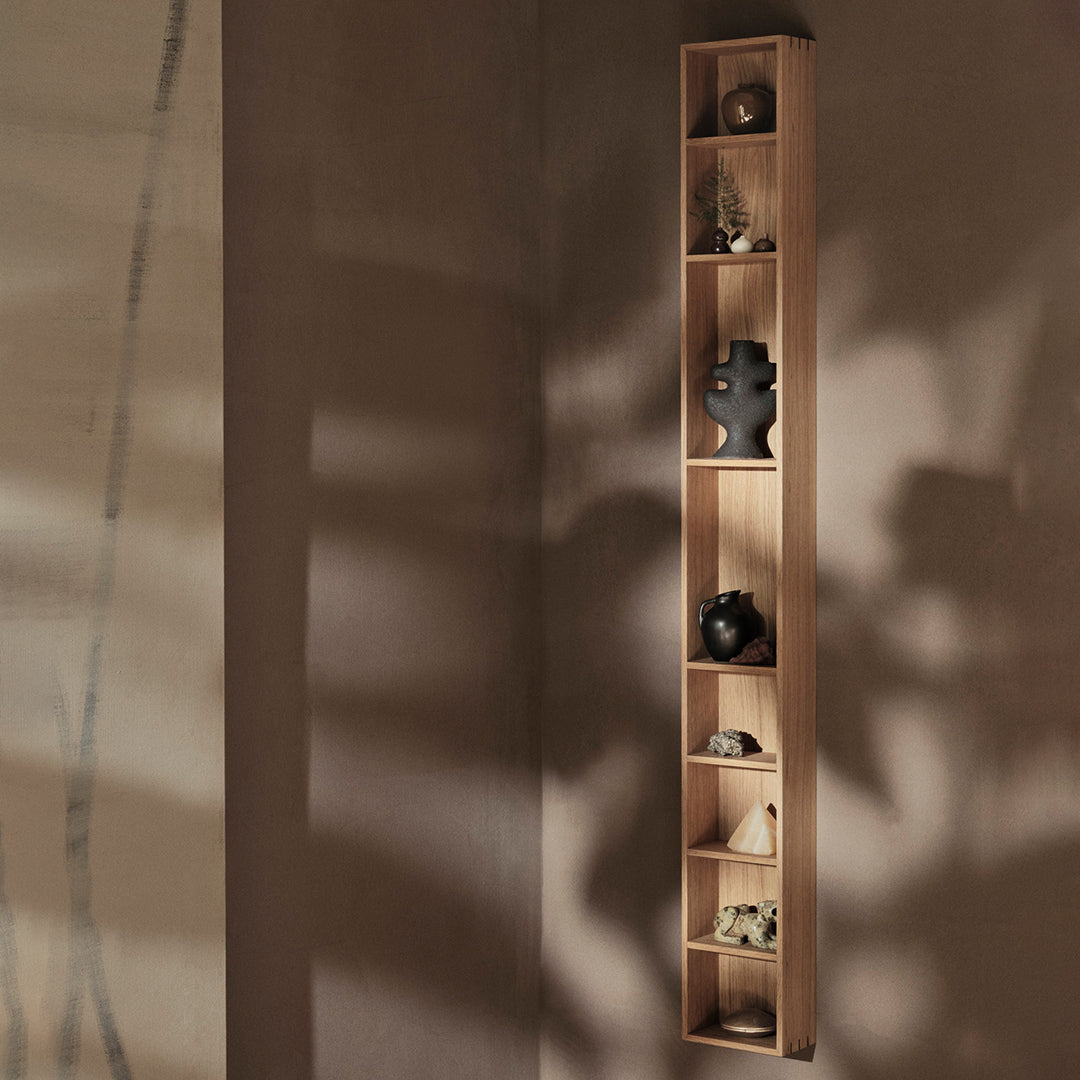 Slim wooden wall shelf in light oak showcasing smooth surfaces and natural wood grain; minimalist design with neutral tones.