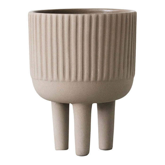 Beige ribbed planter with three legs, showcasing a modern, minimalist design. Perfect for any decor.