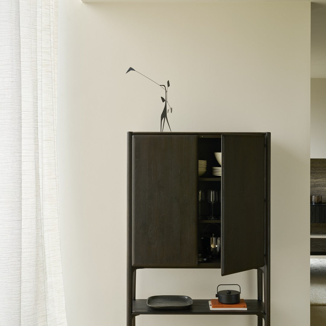 Black wooden cabinet with sleek lines, minimalist design, and contrasting light background accentuating its modern style.