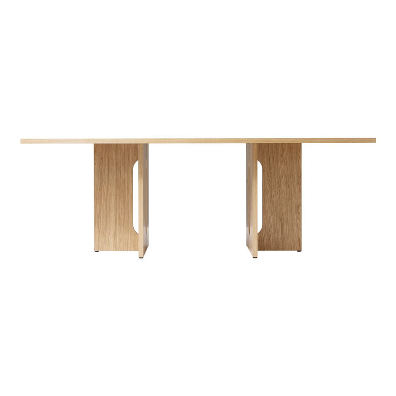 Light oak dining table with a smooth natural finish and sleek geometric patterns in the pedestal design.