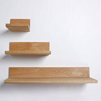 "Three wooden shelves in a light natural oak finish, showcasing smooth textures and clean lines."