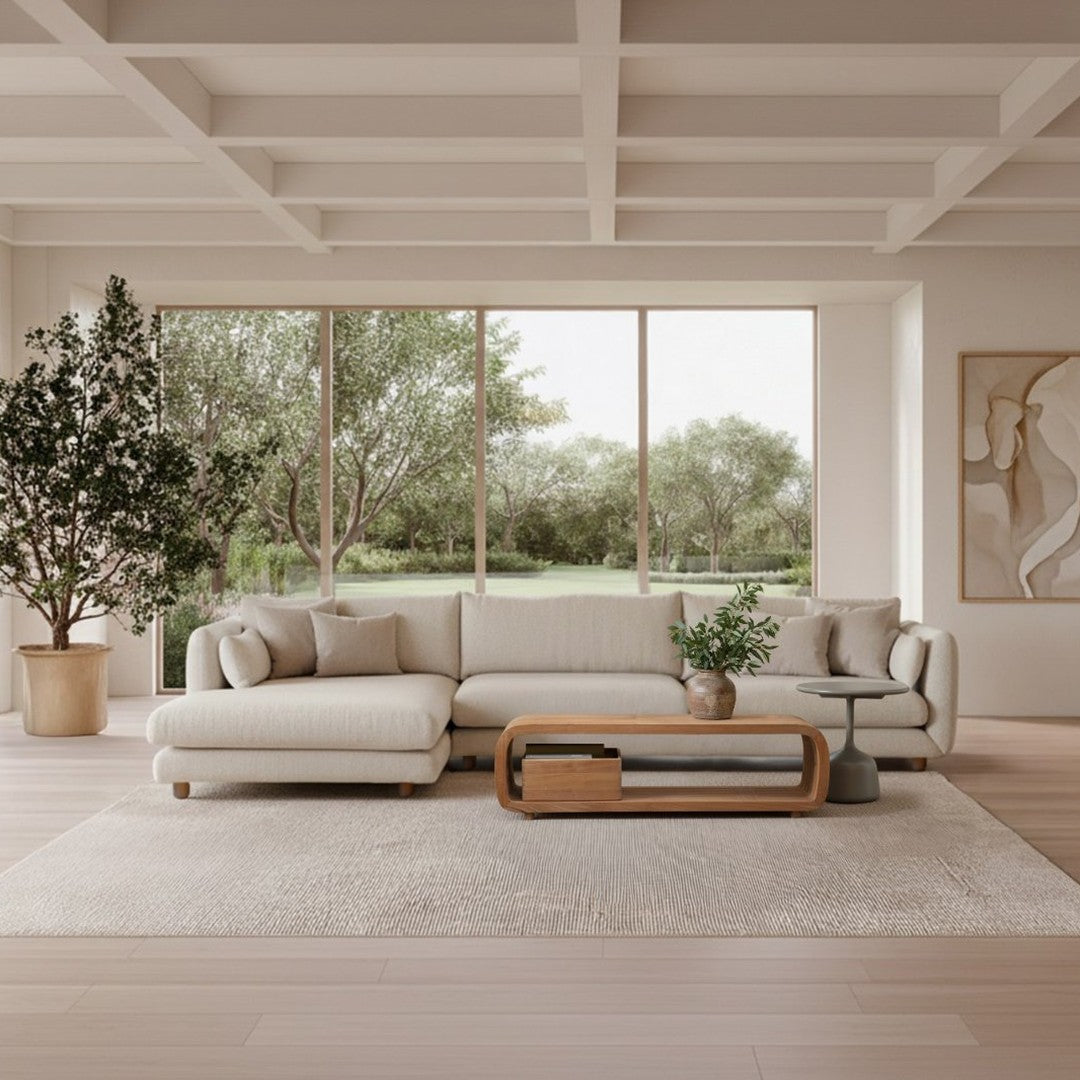 Light beige sectional sofa with soft textures, paired with a natural wood coffee table and neutral-toned rug.