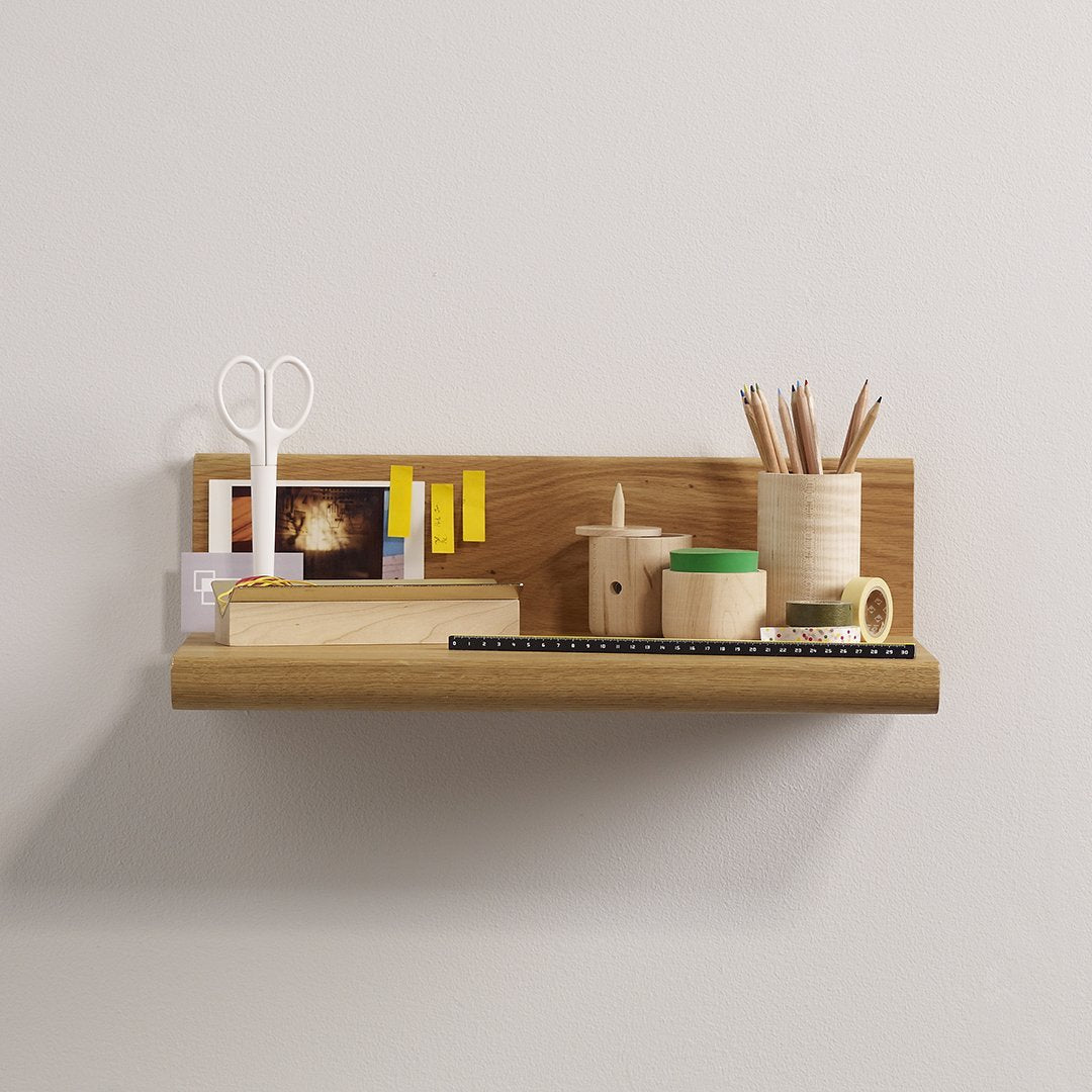 Natural wood shelf with neutral tones, featuring vibrant green, yellow, and tan stationery accents. Minimalistic design.