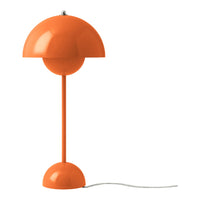 Orange dome-shaped lamp with a sleek pole and round base, adding a pop of color to any space.
