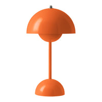 Orange dome-shaped lamp with a smooth finish and minimalist design, featuring a round base and shade.