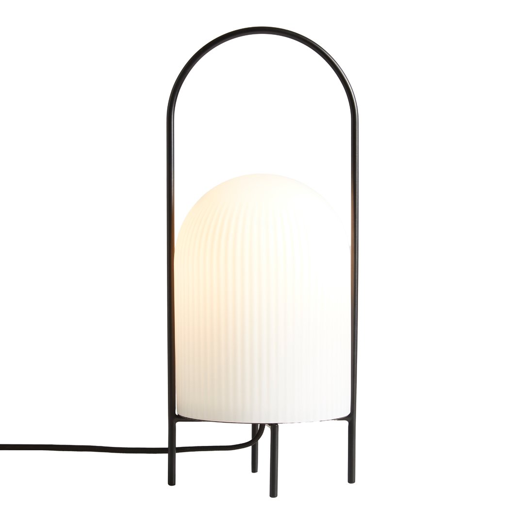 Modern black lamp with a ribbed white glass shade, featuring a sleek, minimalist design and curved frame.