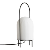 Modern white ribbed lamp with a sleek black frame and minimalist design, adding elegance to any space.