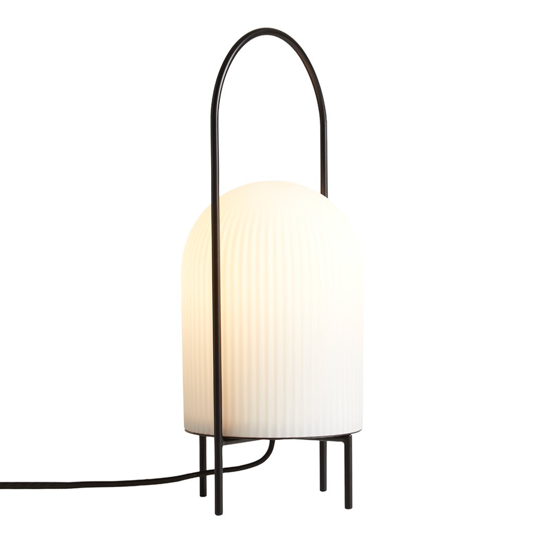 Stylish white ribbed lamp with a sleek black metal frame and minimalist design. Ideal for modern decor.