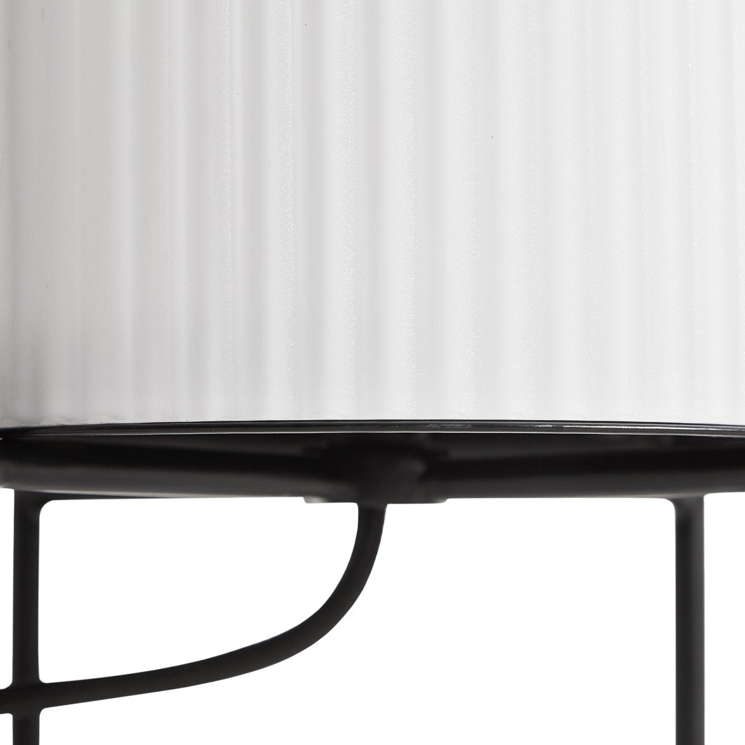 "White ribbed glass lamp shade with black metal base, featuring sleek lines and modern design."