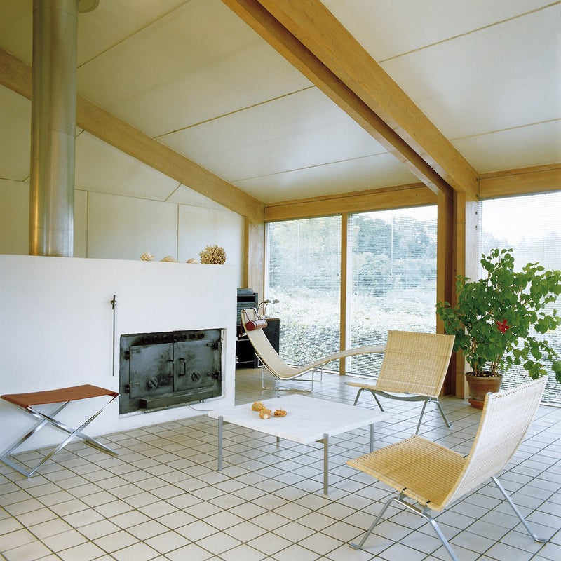 Modern living room featuring light wood beams, neutral tones, and a grid-patterned tile floor. Bright natural light highlights colors.