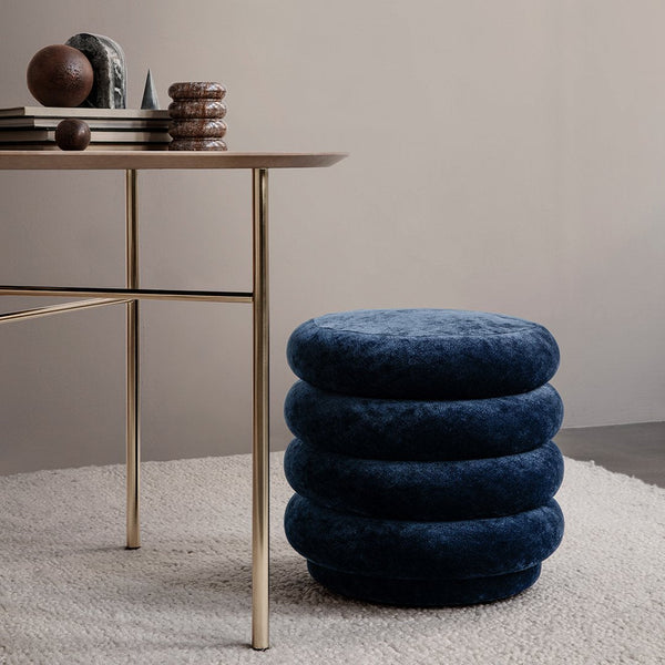 Navy blue round velvet pouf with layered design, complementing a modern workspace aesthetic.