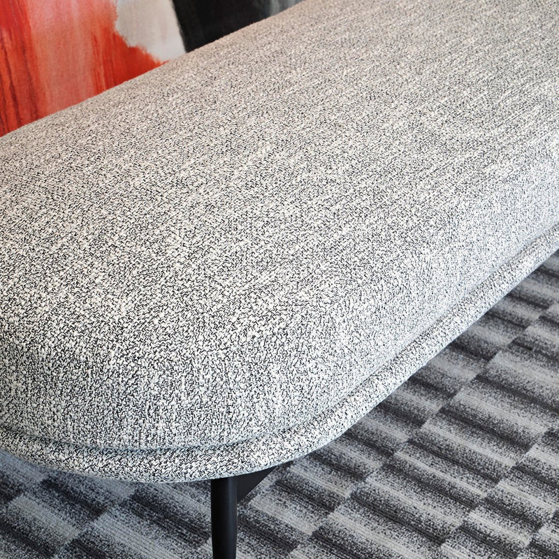 Gray textured upholstery with a subtle pattern, contrasted against a striped black and gray flooring.