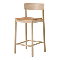 Light wood bar stool with a natural finish and a tan leather seat, minimalist design and sleek lines.