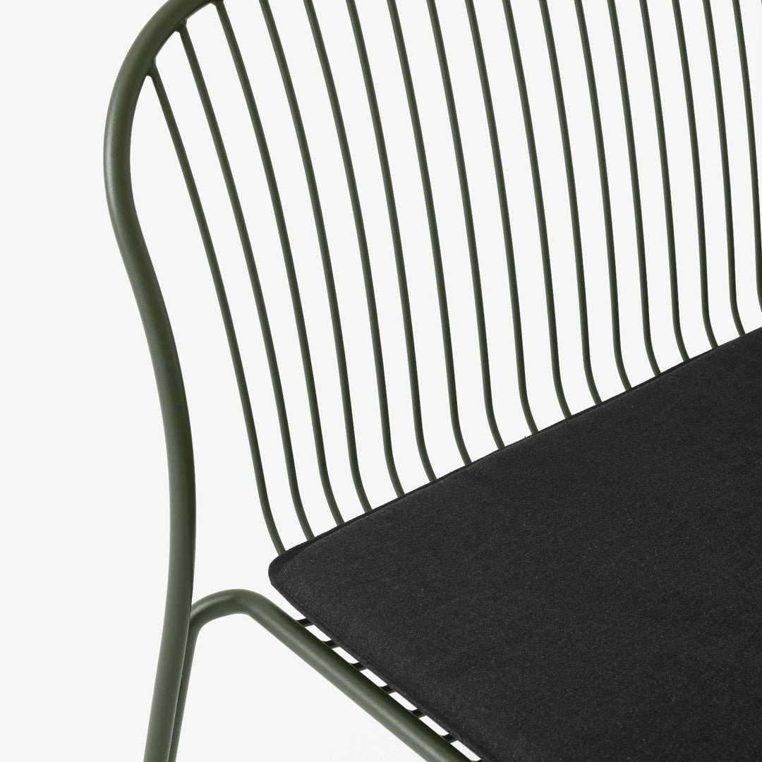 Green metal chair with a sleek, modern design featuring black fabric seat. Minimalist style with clean lines.