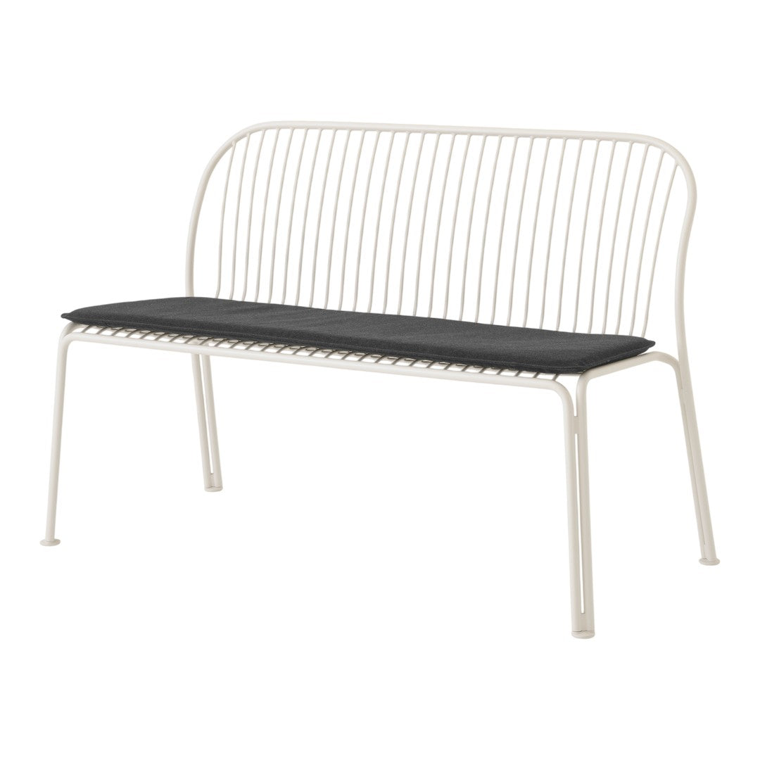 Minimalist white metal bench with a sleek black cushion, featuring a linear pattern in the backrest design.