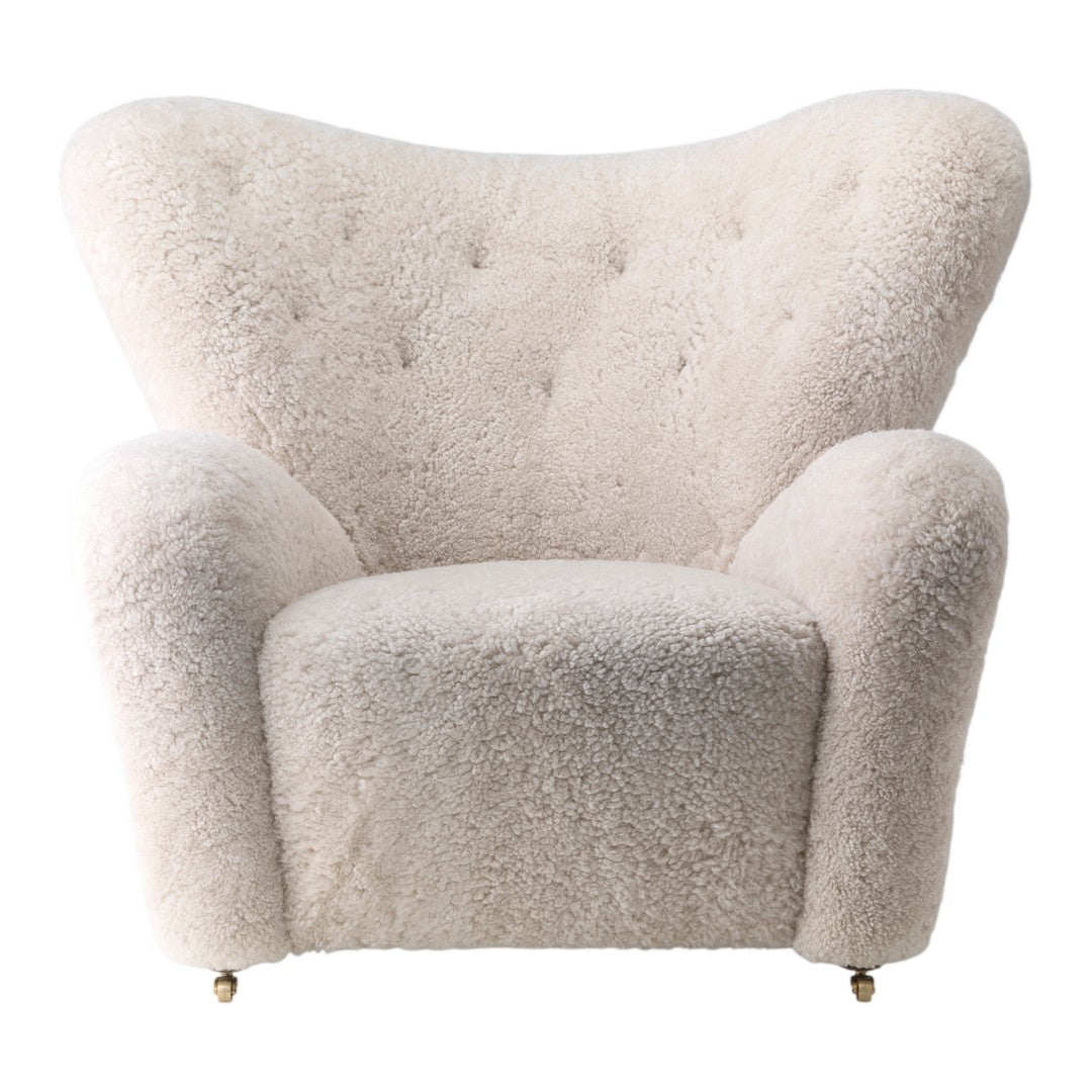 Cozy cream-colored armchair with soft, textured fabric and subtle tufted detailing. Perfect for modern decor.