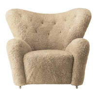 Cream-colored plush armchair with a soft, textured surface and tufted detailing. Ideal for cozy interiors.