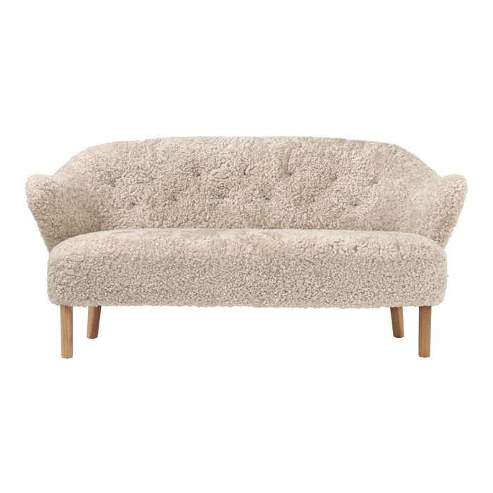 Cream-colored tufted sofa with a soft, textured fabric and natural wooden legs. Ideal for modern interiors.