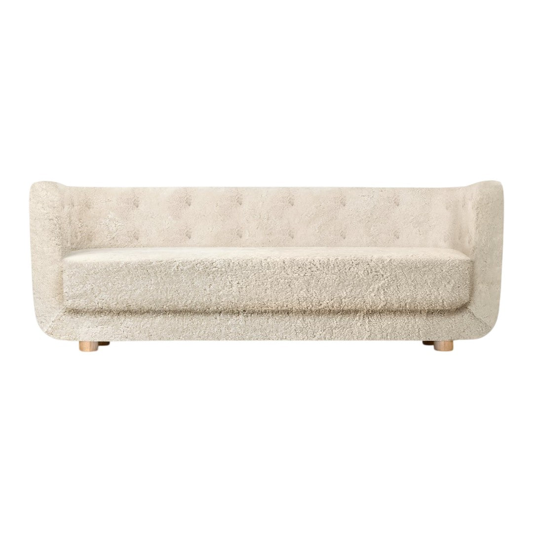Cream-colored, tufted sofa with a soft, textured fabric and minimalistic design on wooden legs.
