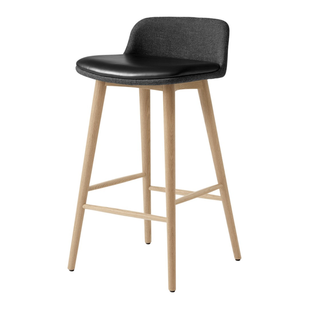 Black upholstered bar stool with light wood legs, featuring clean lines and a minimalist design.