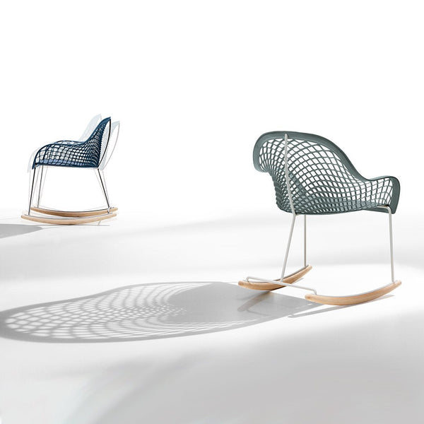 Two modern rocking chairs in navy blue and teal with intricate woven patterns on a minimalist white background.