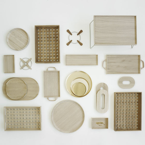 Assorted wooden trays and organizers in light beige with textured patterns, round and rectangular shapes.