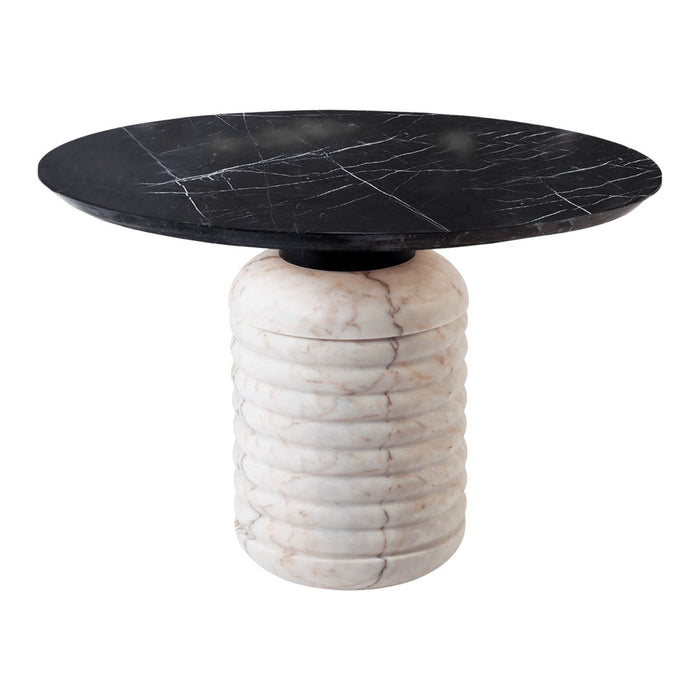Black round tabletop with white veining, resting on a textured cream column base with subtle grooves.