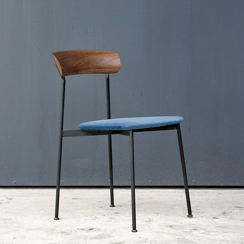 Modern beige curved seating with a round beige top and rust-colored base, set in a minimalistic space.