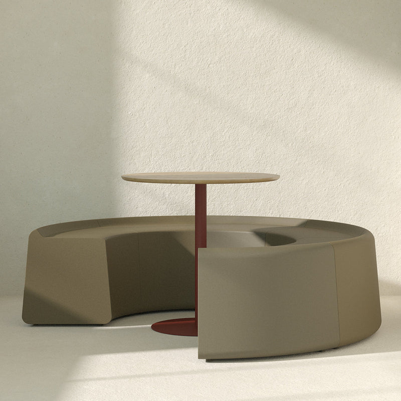 Sleek olive-green lounge seating with a round wood table and contrasting burgundy base, minimalist design, modern aesthetic.