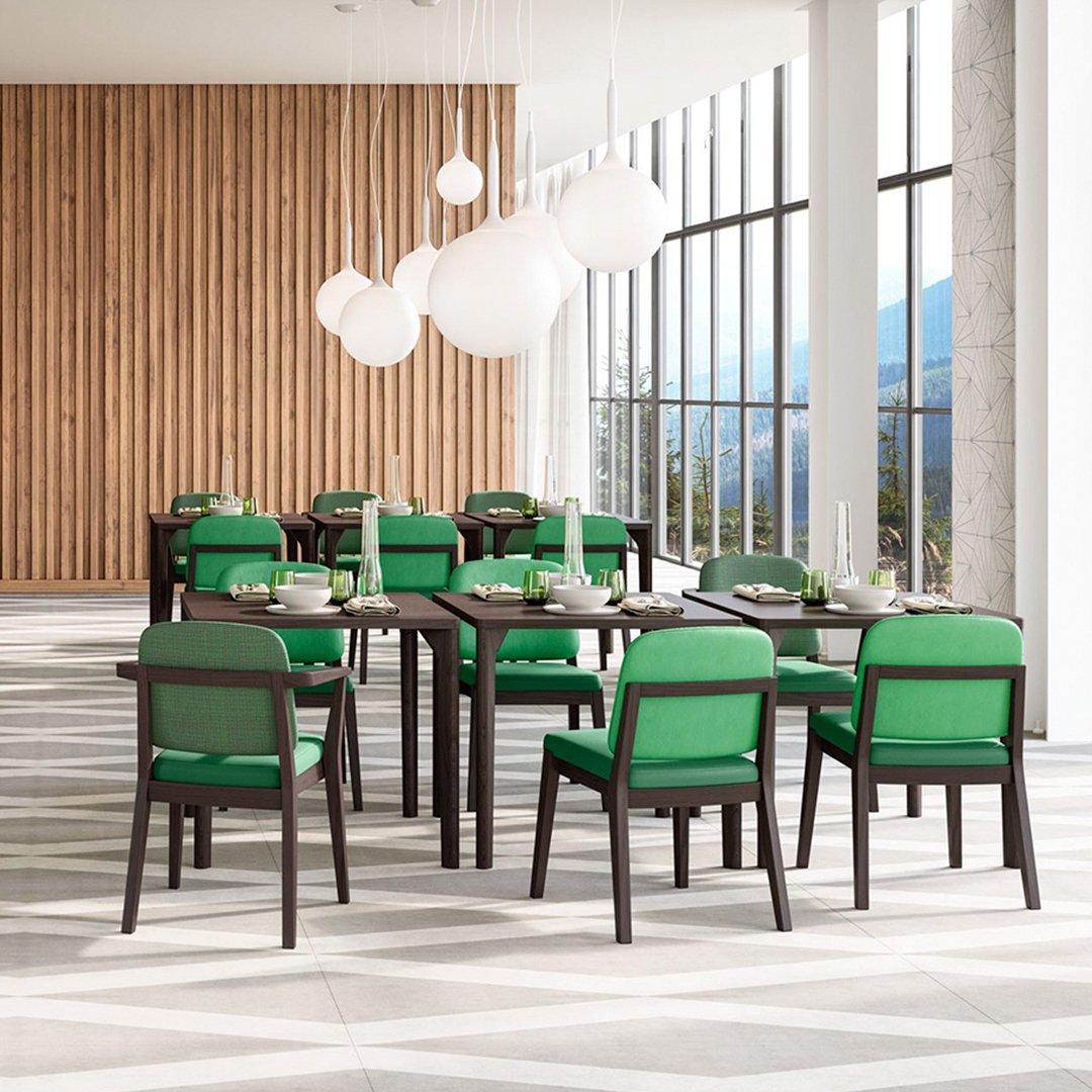Green and black dining chairs arranged around a dark wood table in a modern, light-filled space.
