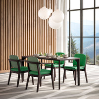 Green upholstered dining chairs around a dark wood table on a geometric gray and white patterned rug.
