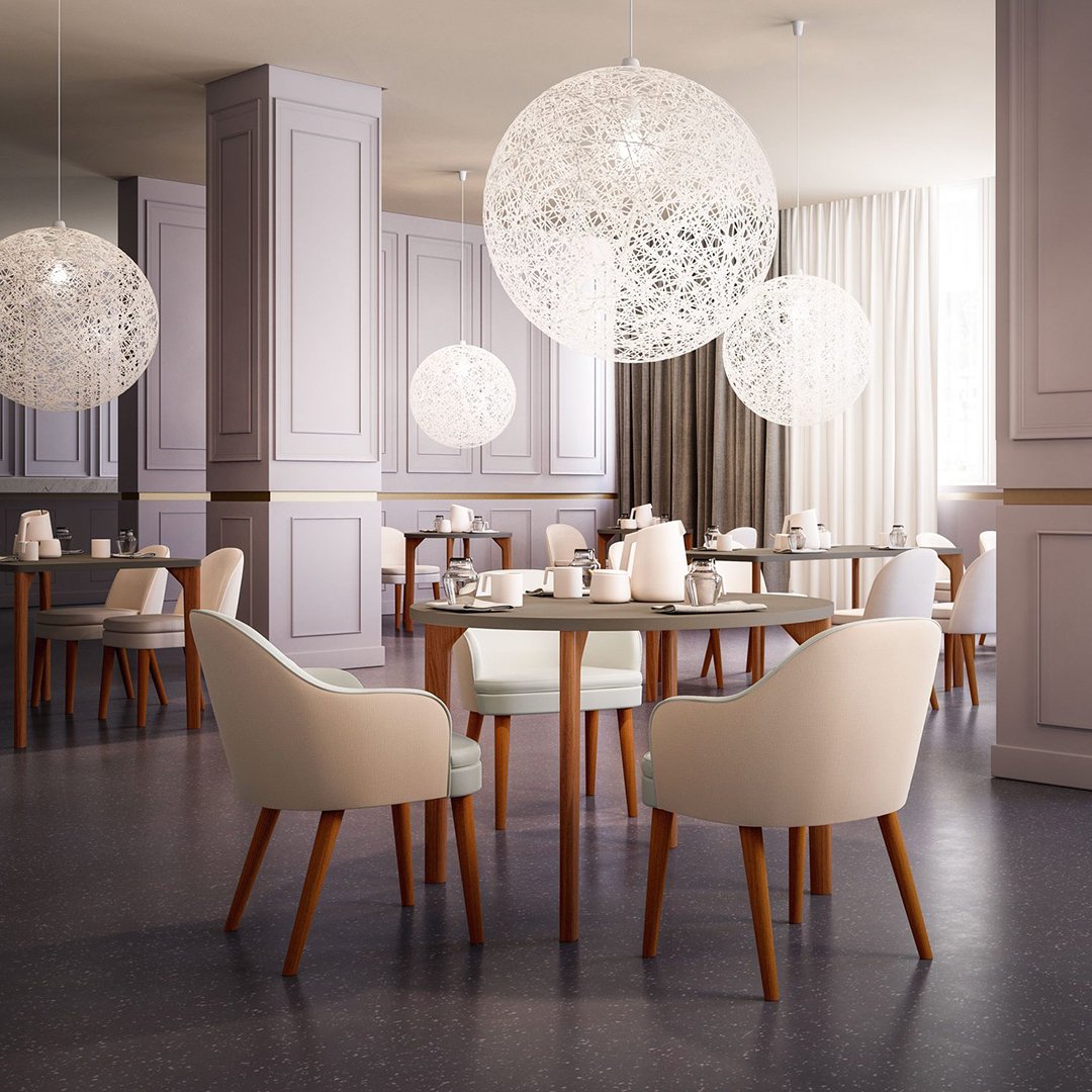 Modern dining room featuring soft beige chairs, light wooden legs, and elegant white pendant lights against a muted backdrop.