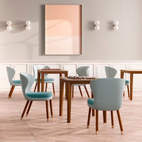 Soft blue chairs with wooden legs in a modern dining room, featuring a light peach and beige wall art.