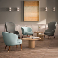 "Elegant armchairs in soft gray and pastel blue, paired with a natural wood coffee table on herringbone patterned floor."