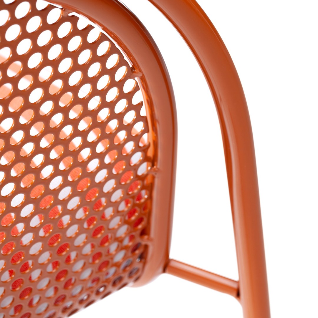Orange metal chair with a perforated pattern, showcasing vibrant hues and a modern design. Perfect for any decor.