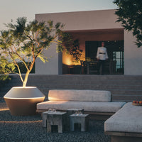 Contemporary outdoor lounge set featuring neutral tones, textured fabrics, and earthy stone accents.