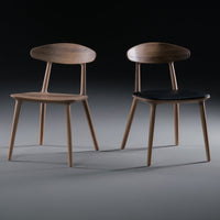 Two modern wooden chairs: one with a light wood finish and the other featuring a dark seat. Simple, elegant design.