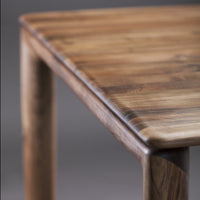Wooden table corner featuring natural brown tones and subtle grain patterns for a rustic, modern look.