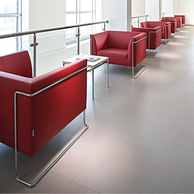 Red modern lounge chairs with sleek chrome frames, arranged in a contemporary, minimalist setting.