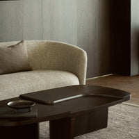 Gray woven sofa with a dark wooden table, featuring subtle textures and earthy tones for a modern aesthetic.